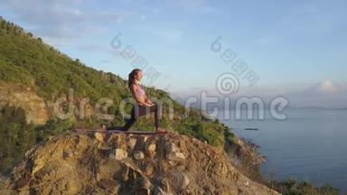 苗条的金发女孩站在石头上的战士姿势对抗山海
